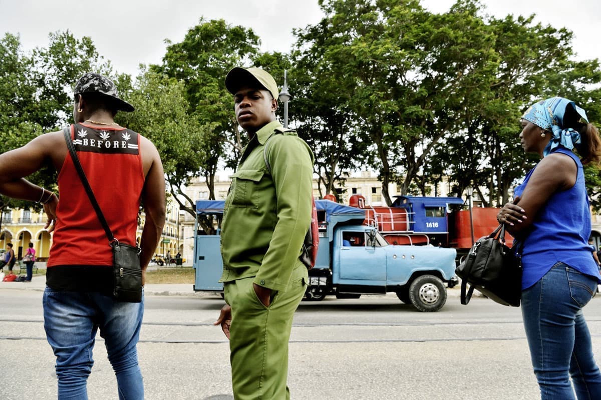 キューバの旅写真_ハバナのバスを待つ軍服の男